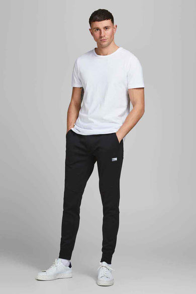 Zwarte joggingbroek van JACK & JONES JEANS INTELLIGENCE, met zakken en witte sneakers.
