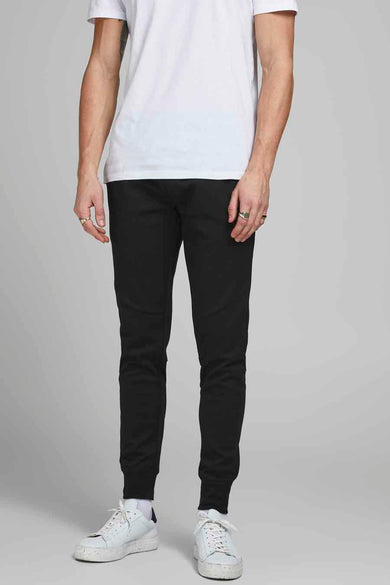 Zwarte joggingbroek van JACK & JONES JEANS INTELLIGENCE, gedragen met een wit T-shirt en witte sneakers.