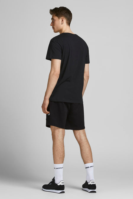 Zwarte korte broek van JACK & JONES JEANS INTELLIGENCE, zijprofiel van model in casual outfit met zwart T-shirt en witte sokken