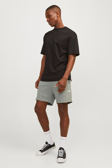 Short vert de JACK & JONES JEANS INTELLIGENCE, avec un style sportif, porté avec un T-shirt noir et des baskets basses.