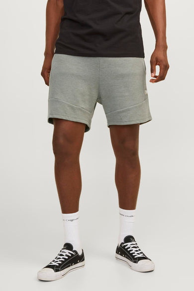 Short vert de JACK & JONES JEANS INTELLIGENCE, avec une couture diagonale et porté avec des sneakers et des chaussettes blanches.