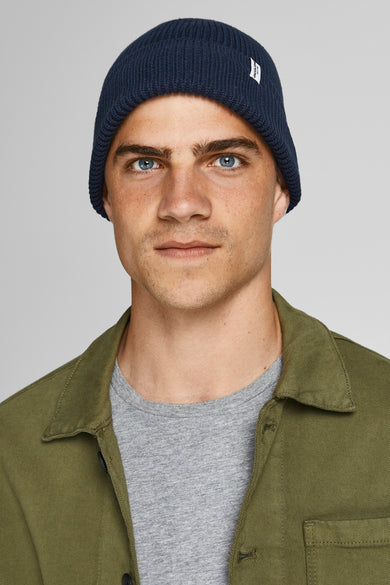 Blauwe muts van ACCESSORIES BY JACK & JONES, met geribbelde textuur, gedragen door een man met een groen overhemd en grijs shirt.
