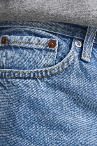 Jean slim en denim de JACK & JONES JEANS INTELLIGENCE, avec des accessoires et des boutons dorés, plus un haut gris.