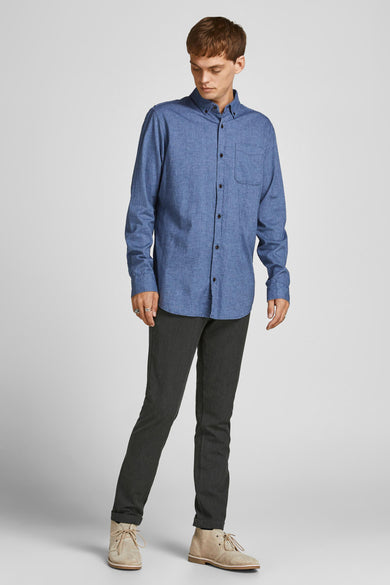 Grijze broek van JACK & JONES JEANS INTELLIGENCE, gecombineerd met een blauw overhemd en suède schoenen.