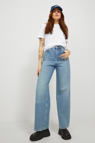 Wit T-shirt van JJXX, gedragen met wijde jeans en een pet.