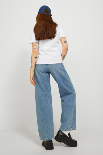 Wit T-shirt van JJXX, gedragen met wijde jeans en zwarte loafers, rug aanzicht.
