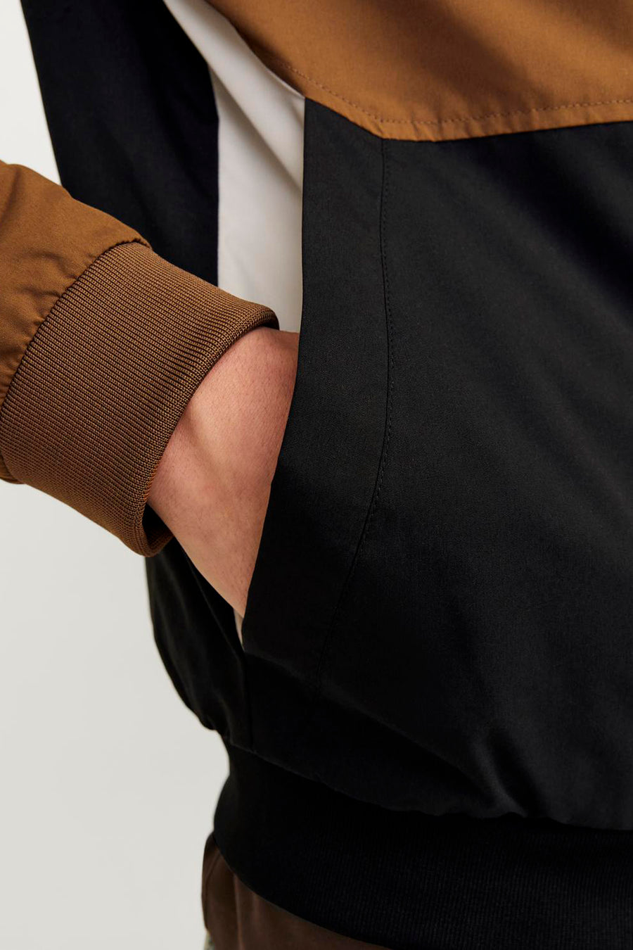Veste courte marron de ORIGINALS BY JACK & JONES, avec des accents noirs et blancs et une main dans la poche.