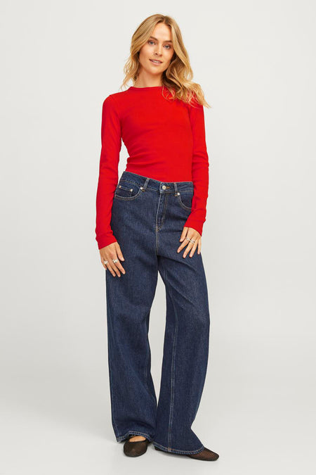 Rood T-shirt met lange mouwen van JJXX, gecombineerd met een wijde jeans en zwarte ballerina's.
