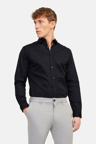 Zwart overhemd van PREMIUM by JACK & JONES, met lange mouwen en gedragen met grijze pantalon.
