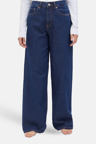 Donkerblauwe denim wide jeans van JJXX, met een lange wijde pijp en een witte top.

