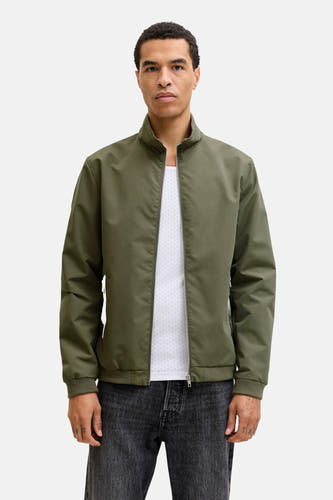 Groene korte jas van CORE BY JACK & JONES, gedragen over een wit hemd en donkere jeans.