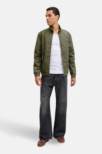 Korte groene jas van CORE BY JACK & JONES, gedragen over een wit hemd en wijde donkergrijze jeans.