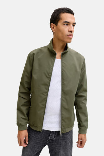 Korte groene jas van CORE BY JACK & JONES, gedragen over een wit hemd en donkere jeans.
