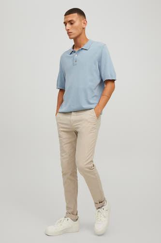 Beige chino van JACK & JONES JEANS INTELLIGENCE, gecombineerd met een lichtblauwe polo en witte sneakers.