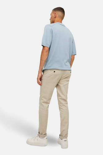Beige chino van JACK & JONES JEANS INTELLIGENCE, gezien van achteren, met lichtblauw poloshirt en witte sneakers.
