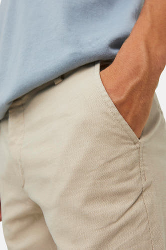 Beige chino van JACK & JONES JEANS INTELLIGENCE, met subtiele textuur en een hand in de zak.