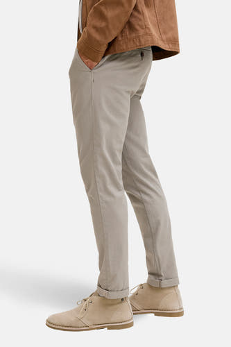 Groene chino van JACK & JONES JEANS INTELLIGENCE, met steekzak en omgeslagen broekspijpen, gecombineerd met bruin jack en suède schoenen.