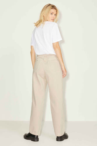 Jean droit beige de JJXX, avec poches arrière, porté avec un t-shirt blanc et des chaussures noires.