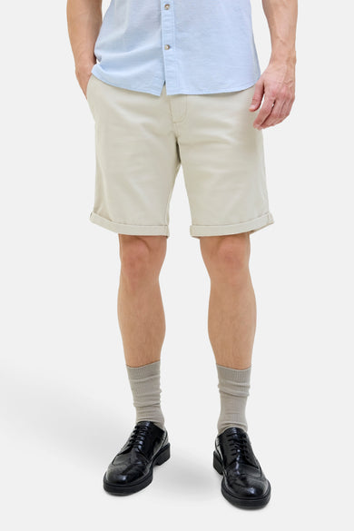 Ecru short van JACK & JONES JEANS INTELLIGENCE, met opgerolde zoom en een losse, lichtblauwe blouse.