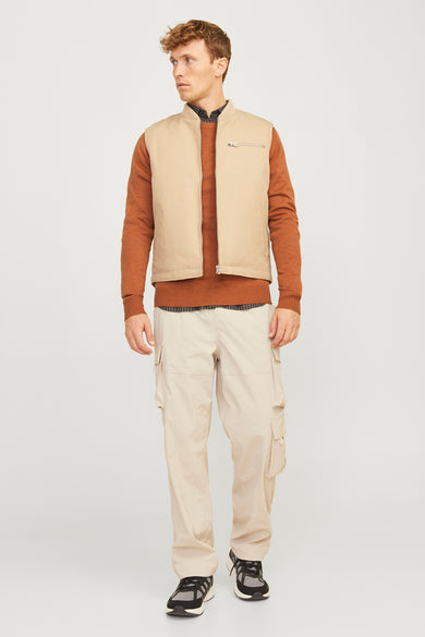 Bruine trui met ronde hals van PREMIUM BLUE by JACK & JONES, gedragen onder een beige vest en cargo broek.