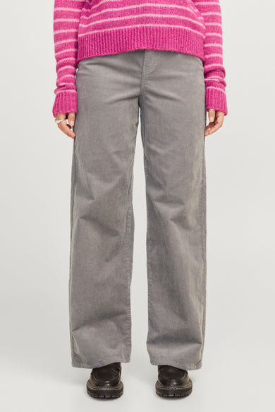 Grijze corduroy broek van JJXX, met een wijde pijp en gecombineerd met een roze gestreepte trui.
