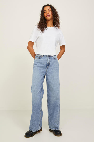 Jeans wide van JJXX, in mid blue denim, gecombineerd met een wit T-shirt en zwarte schoenen.
