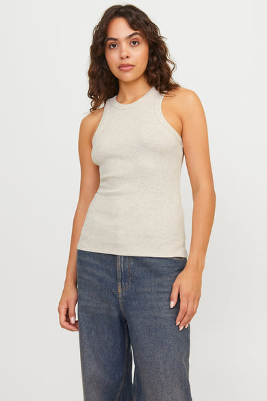 Ecru mouwloze top van JJXX, gedragen met blauwe jeans.