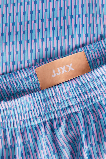 Blauwe dames short van JJXX met geometrisch patroon, tailleband en merklabel.
