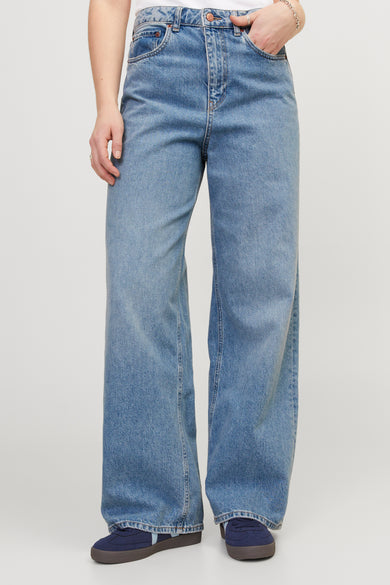 Wijdvallende jeans van blauw denim, van JJXX, met steekzakken en donkerblauwe schoenen.
