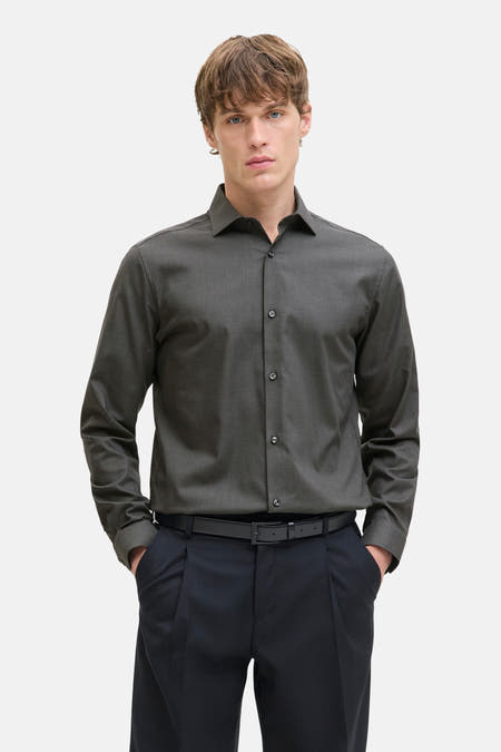 Grijs heren overhemd met lange mouwen van PREMIUM by JACK & JONES, gedragen met een zwarte broek en riem.
