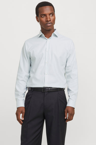 Chemise verte à manches longues de PREMIUM by JACK & JONES, portée avec un pantalon noir et une ceinture.