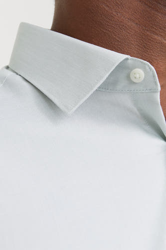 Groen overhemd met lange mouwen van PREMIUM by JACK & JONES, close-up van de kraag en een knoop.