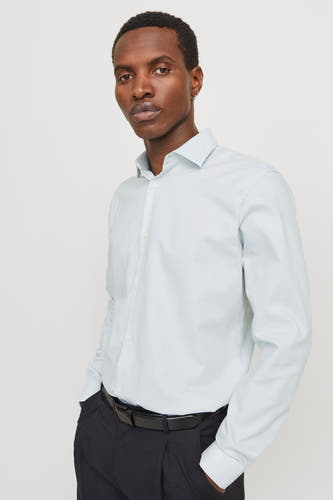 Groen overhemd met lange mouwen van PREMIUM by JACK & JONES, met zwarte pantalon en riem.

