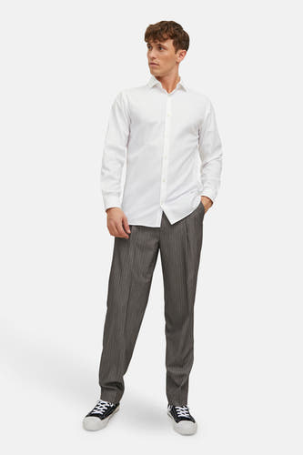 Chemise blanche à manches longues de PREMIUM by JACK & JONES, portée avec un pantalon gris à rayures de craie et des baskets.
