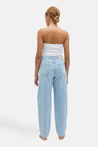 Lichtblauwe mom jeans van JJXX, gezien vanaf de achterkant, gecombineerd met een witte top.