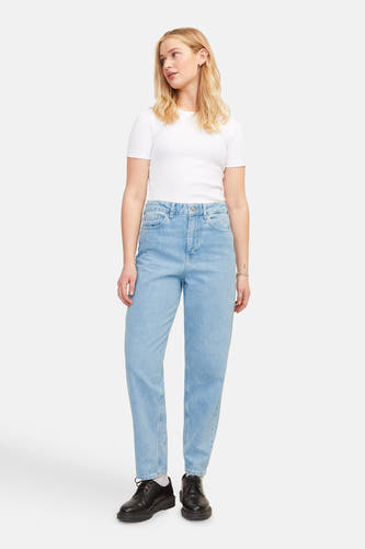 Lichtblauwe mom jeans van JJXX, gecombineerd met een wit T-shirt en zwarte schoenen.