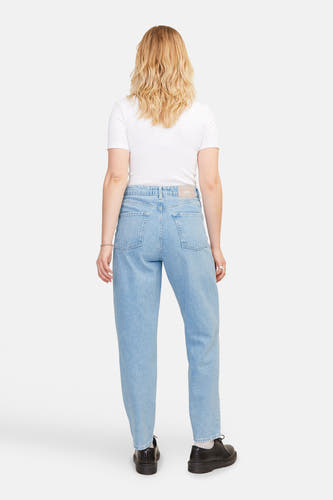 Lichtblauwe mom jeans van denim van JJXX, gezien van achteren, gecombineerd met een wit shirt en zwarte schoenen.
