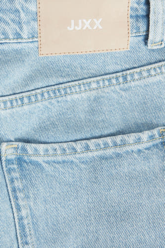 Lichtblauwe mom jeans van JJXX, close-up van de achterzakken en een patch met het logo.
