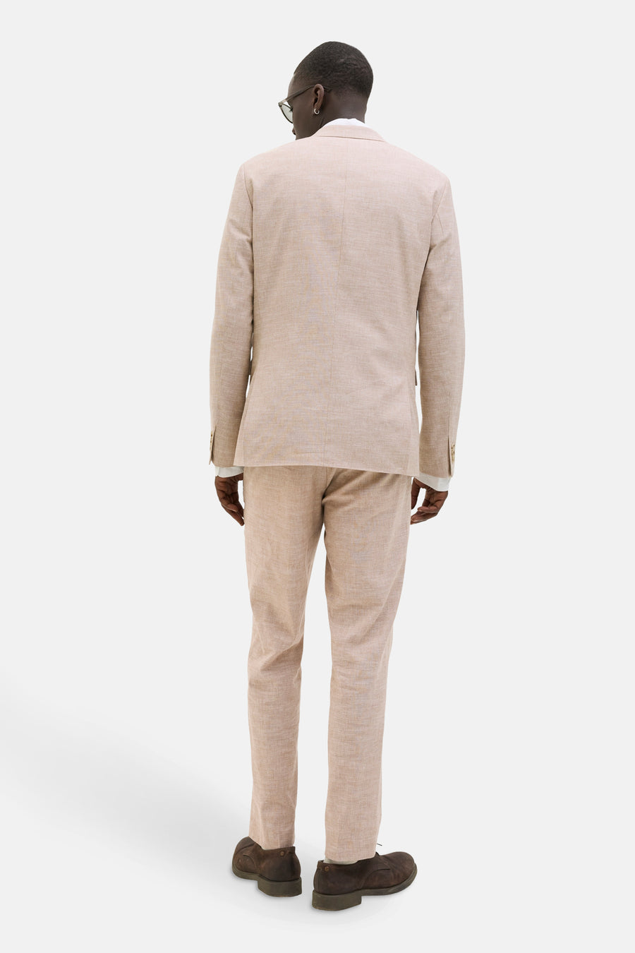 Beige kostuumbroek van PREMIUM by JACK & JONES, met een lichte textuur en bruine schoenen.
