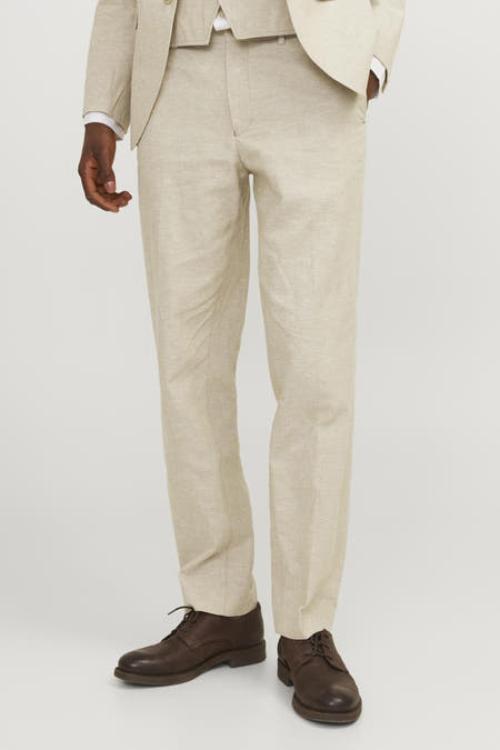 Pantalon de costume écru PREMIUM by JACK & JONES, vu de derrière avec des chaussures sombres.