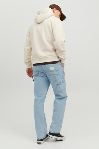Jean en denim bleu clair large de JACK & JONES JEANS INTELLIGENCE, avec des poches et un hoodie beige.
