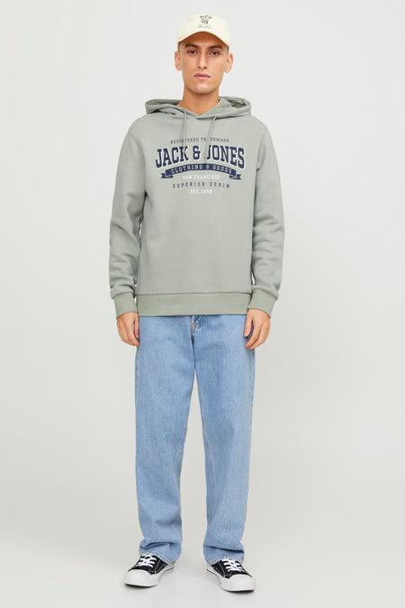 Pull-over vert vert capuche d'ORIGINALS par JACK & JONES, avec une impression graphique et associé à des jeans bleus et des baskets noires.