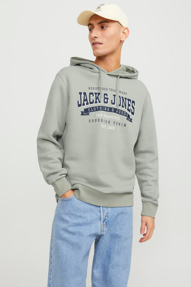 Pull-over vert de cap ORIGINALS par JACK & JONES, avec logo sur la poitrine et associé à des jeans et un casque.