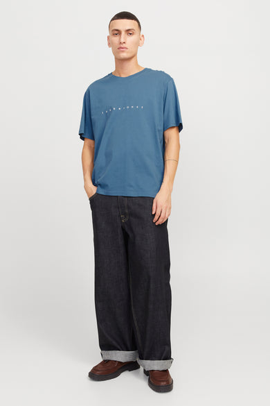 Blauw T-shirt met korte mouwen van ORIGINALS BY JACK & JONES, gedragen met wijde jeans en bruine schoenen.