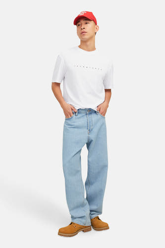 T-shirt blanc à manches courtes d'ORIGINALS par JACK & JONES, porté avec des jeans bleu clair et des chaussures en cuir de suède.