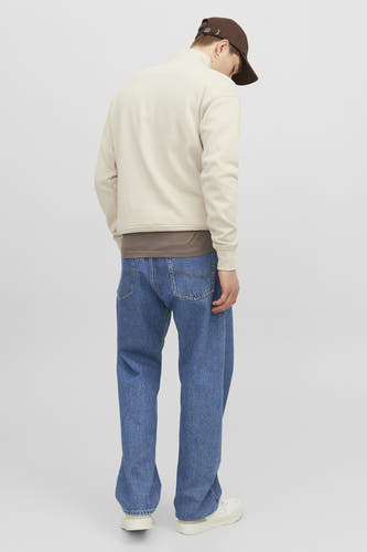 Jean Alex de JACK & JONES JEANS INTELLIGENCE, en denim bleu moyen, vu de dos, avec des baskets blanches et un chapeau marron.