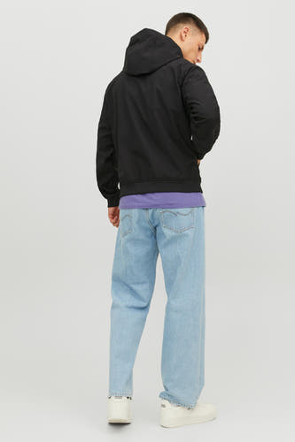 Zwarte korte jas van CORE BY JACK & JONES, met capuchon, gecombineerd met een paars shirt en wijde jeans.