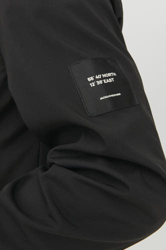 Zwarte korte jas van CORE BY JACK & JONES, met een merklogo-embleem op de mouw.
