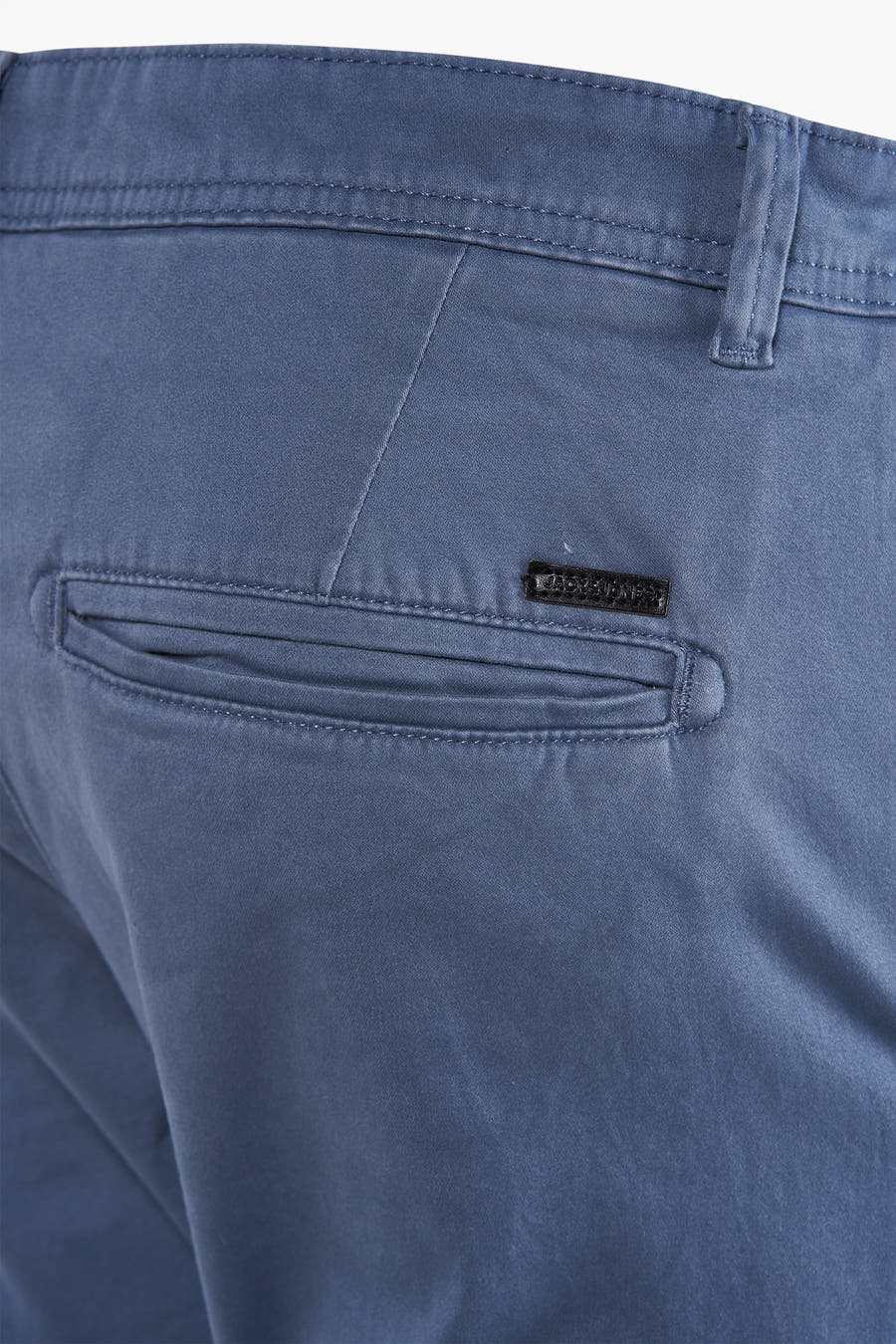 Blauwe chino van JACK & JONES JEANS INTELLIGENCE, met paspelzak aan de achterkant en subtiel logo detail.
