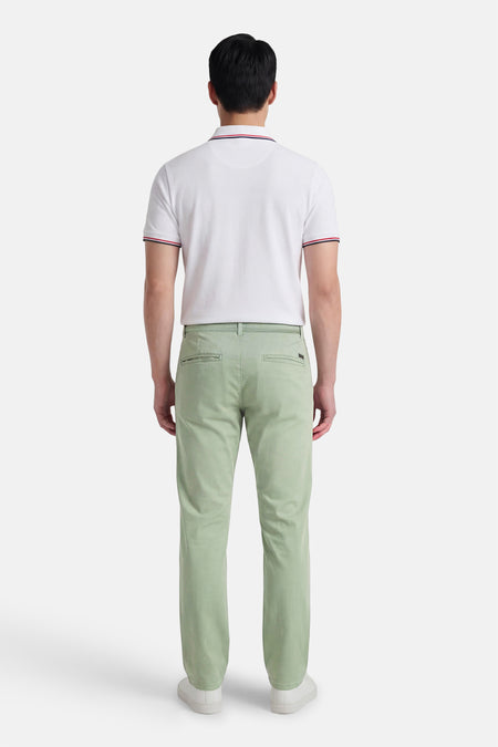 Groene chino van JACK & JONES JEANS INTELLIGENCE, gezien van achteren, gecombineerd met een wit poloshirt en witte schoenen.